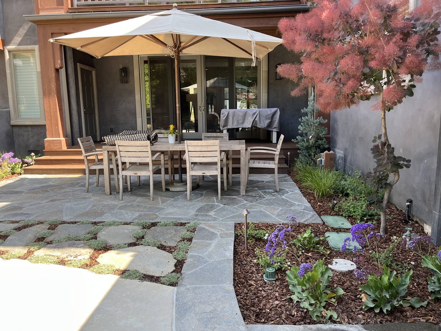 Twin Palms Landscape flagstone patio with planting beds and outdoor dining area