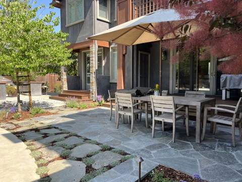 Flagstone patio with outdoor dining set and planting