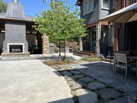 Outdoor stone fireplace beside a flagstone patio