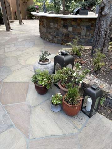Stone outdoor kitchen and bar on a flagstone patio