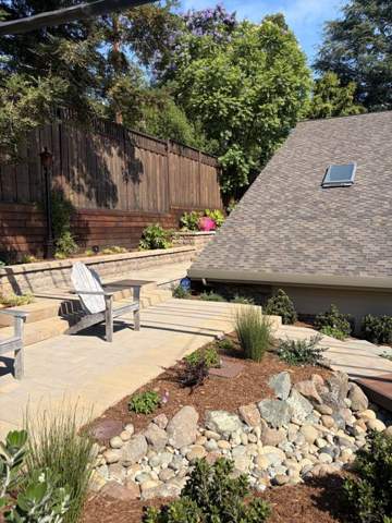 River rock drainage bed with planting beside a patio