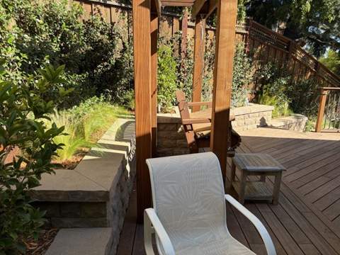 Deck seating area with pergola and surrounding planting