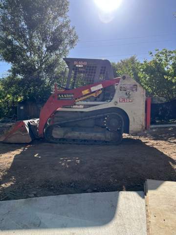 Skid steer grading and base preparation for a new artificial turf lawn