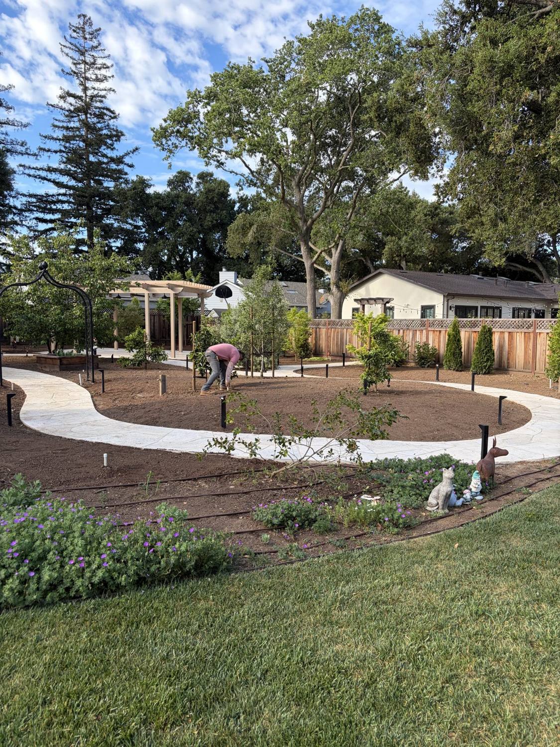 Newly designed circular planting bed with lawn and mulch pathways